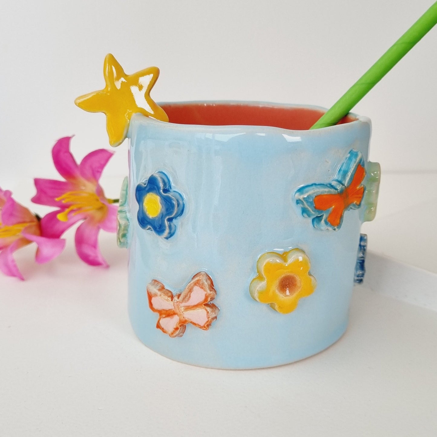 Colorful Tiki mug adorned with 3D flowers and butterflies. Starfish on the rim