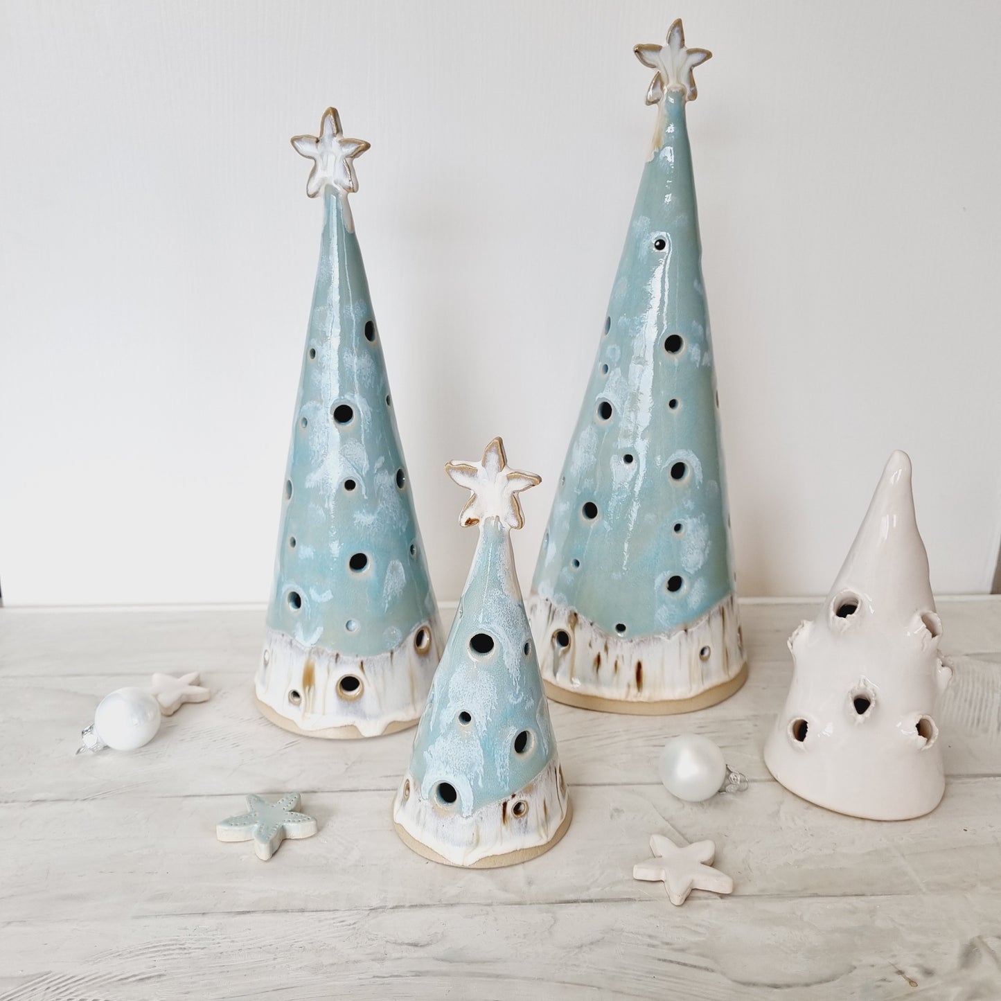 Teal blue turquoise Christmas trees for beach theme, coastal Christmas. The Christmas tree is adorned with a sandy color starfish on top.