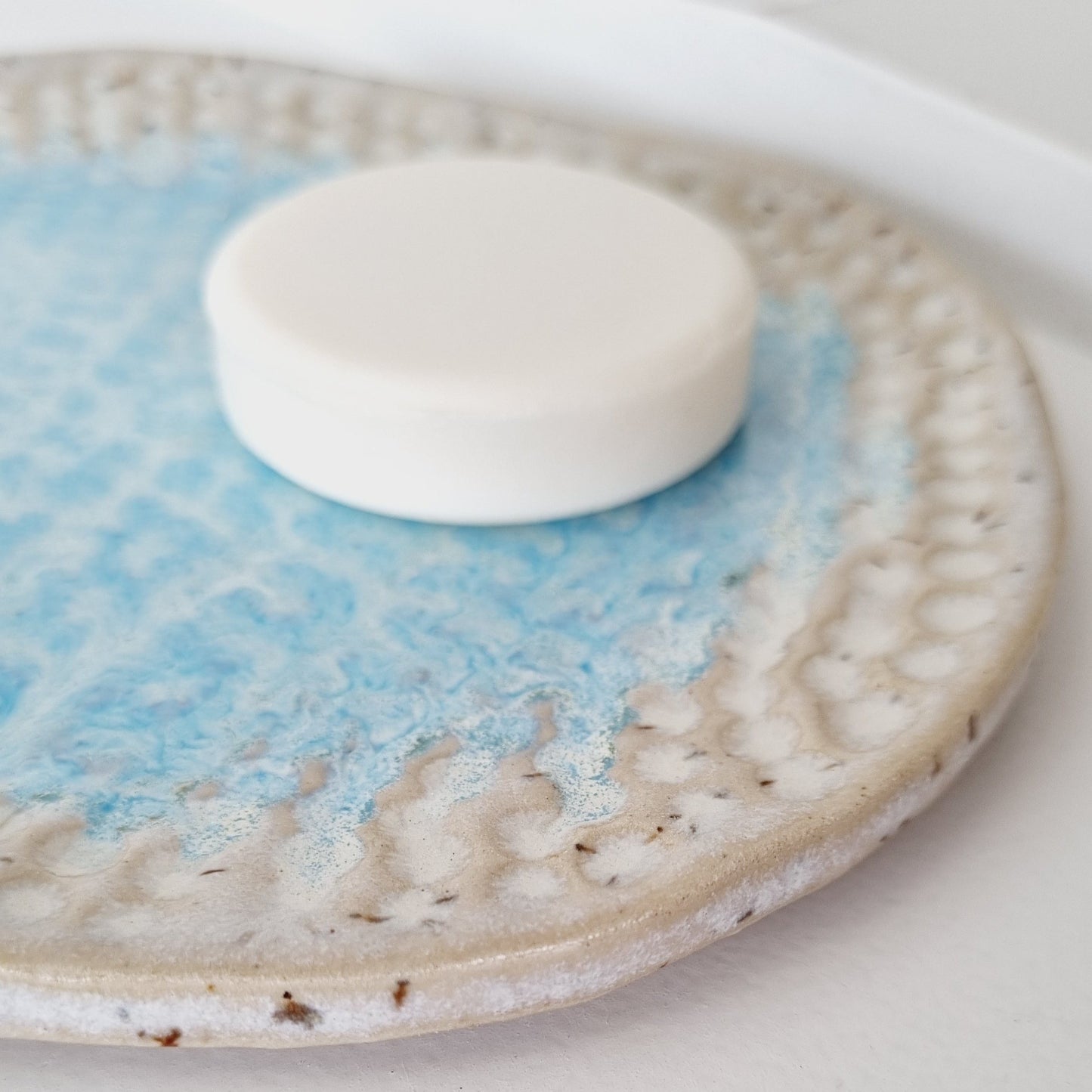 Turquoise blue soap dish. The imprint reflects the beach