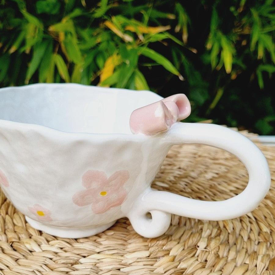 Handpinched cup with pink flowers and a pink bow