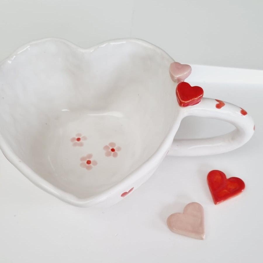 Whimsical mug handmade in a heart shape. ceramic hearts on the rim