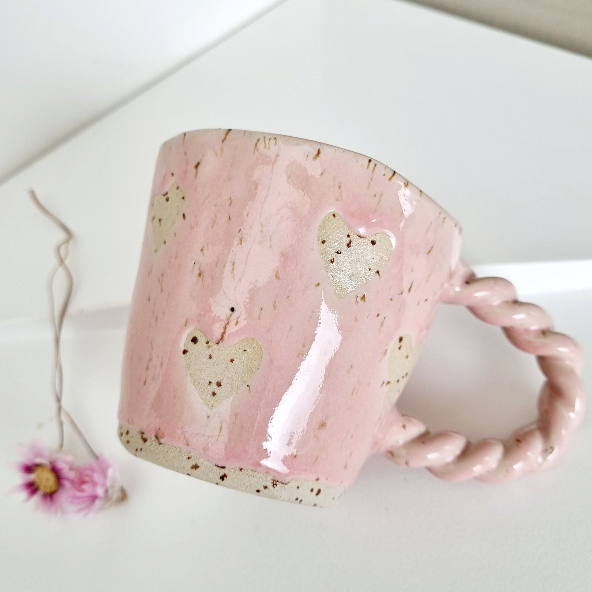 Pink mug made from speckled clay with hearts