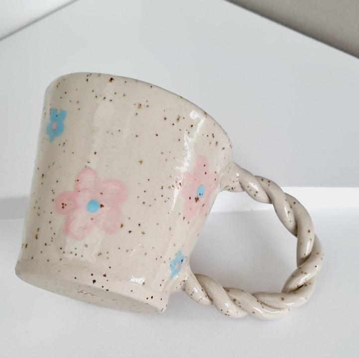 Handmade speckled mug, handpainted with blue and pink flowers. Braided handle